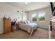 Bright bedroom features soft carpet, large windows overlooking mature landscaping, and standard bedroom furniture at 1517 Yale Castle Ct, Ruskin, FL 33570