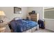 A comfortably furnished bedroom features a bed, desk and dresser bathed in natural light from a side window at 1517 Yale Castle Ct, Ruskin, FL 33570