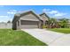 View of a home featuring an attached two-car garage, manicured lawn, and a charming front yard at 1517 Yale Castle Ct, Ruskin, FL 33570