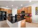 Kitchen featuring a large island with granite countertop, wood cabinets, and appliances at 1517 Yale Castle Ct, Ruskin, FL 33570