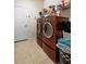 Efficient laundry room with modern washer and dryer, tile flooring, and ample storage space at 1517 Yale Castle Ct, Ruskin, FL 33570