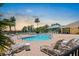 Community pool and lounge area surrounded by palm trees and lounge chairs at 1517 Yale Castle Ct, Ruskin, FL 33570