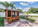 Backyard with wooden gazebo structure housing a hot tub, fire pit and hammock at 1524 Rhodeswell Ln, Dover, FL 33527