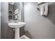 Half bath featuring pedestal sink, decorative mirror, and a neutral color palette at 1524 Rhodeswell Ln, Dover, FL 33527