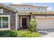 Close up of the front door with stone facade and neatly trimmed shrubbery at 1524 Rhodeswell Ln, Dover, FL 33527