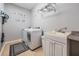 Well-lit laundry room with washer, dryer, utility sink, and ample storage space at 1524 Rhodeswell Ln, Dover, FL 33527