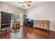 Bright living room features hardwood floors, large window and a ceiling fan at 1524 Rhodeswell Ln, Dover, FL 33527