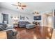 Comfortable living room with hardwood floors, ceiling fans, a gray sofa, and a wall-mounted television at 1524 Rhodeswell Ln, Dover, FL 33527