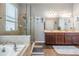 Modern main bathroom with double sinks, a soaking tub, and a walk-in shower with glass enclosure at 1524 Rhodeswell Ln, Dover, FL 33527