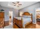 Spacious main bedroom with hardwood floors, a ceiling fan, and access to an en-suite bathroom at 1524 Rhodeswell Ln, Dover, FL 33527