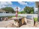 Outdoor kitchen featuring a built-in grill, granite countertop, sink, mini fridge, and shade umbrella at 1524 Rhodeswell Ln, Dover, FL 33527