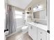 Well-lit bathroom with a shower-tub combo, white vanity, and modern fixtures at 16928 Hawkridge Rd, Lithia, FL 33547