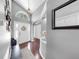 Welcoming foyer with hardwood floors, arched doorway, a transom window and stylish decorations at 16928 Hawkridge Rd, Lithia, FL 33547