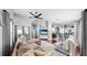 Open-concept living room with wood floors, sectional sofa, kitchen with bar seating, and a ceiling fan at 16928 Hawkridge Rd, Lithia, FL 33547