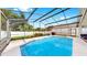 Beautiful pool in screened-in lanai with patio seating, dining, and lush landscaping at 16928 Hawkridge Rd, Lithia, FL 33547