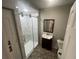 Bathroom featuring a glass enclosed shower with white marble tiling and a vanity with a square mirror at 18127 Us Highway 41, Spring Hill, FL 34610