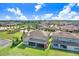 Expansive backyard view showcasing a screened porch and well-manicured lawn in a lush community at 18824 Birchwood Groves Dr, Lutz, FL 33558
