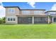 Home exterior view with a large, green lawn and a screened patio visible from the backyard at 18824 Birchwood Groves Dr, Lutz, FL 33558