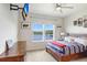 Bedroom with large windows offering a scenic lake view, complete with mounted TV and ceiling fan at 18824 Birchwood Groves Dr, Lutz, FL 33558