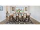 Dining room with a rectangular table, a patterned rug, a modern chandelier and seating for eight at 18824 Birchwood Groves Dr, Lutz, FL 33558