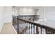 Bright loft area features ornamental wrought iron railing and plush carpet flooring at 18824 Birchwood Groves Dr, Lutz, FL 33558