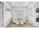 Cozy sitting room featuring tufted white sofa and bright windows at 18824 Birchwood Groves Dr, Lutz, FL 33558