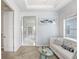 Bright sitting room with white sofa and glass-topped table near bedroom at 18824 Birchwood Groves Dr, Lutz, FL 33558