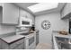 Kitchen features white appliances, light gray cabinets, and a Roman numeral clock at 1948 Elaine Dr, Clearwater, FL 33760