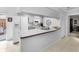 Bright kitchen features white appliances, light gray cabinets, and a breakfast bar at 1948 Elaine Dr, Clearwater, FL 33760