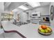 Bright kitchen features white appliances, light gray cabinets, and breakfast bar at 1948 Elaine Dr, Clearwater, FL 33760