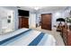 Spacious main bedroom with blue walls includes a TV, dresser, closet, and exercise equipment at 1948 Elaine Dr, Clearwater, FL 33760