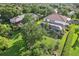 Expansive aerial view of the home with a screened pool and lush, green landscaping and trees at 19711 Wellington Manor Blvd, Lutz, FL 33549