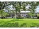 Spacious backyard view of the home, screened pool, and lush green landscaping at 19711 Wellington Manor Blvd, Lutz, FL 33549