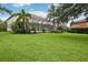 The home features a large backyard with tropical landscaping and screened-in patio area at 19711 Wellington Manor Blvd, Lutz, FL 33549