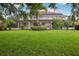 Beautiful backyard and patio with verdant lawn, garden, and screened lanai with lovely home at 19711 Wellington Manor Blvd, Lutz, FL 33549