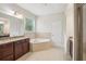 Bright bathroom with double vanity, soaking tub, and tiled floors at 19711 Wellington Manor Blvd, Lutz, FL 33549