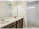 Bright bathroom with double sinks, a large mirror, and tiled shower/tub at 19711 Wellington Manor Blvd, Lutz, FL 33549