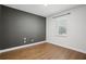 Empty bedroom with hardwood floors, one window, light walls and a single painted accent wall at 19711 Wellington Manor Blvd, Lutz, FL 33549