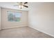 Cozy bedroom featuring neutral carpet, a ceiling fan, and natural light from a large window at 19711 Wellington Manor Blvd, Lutz, FL 33549