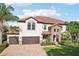 Stunning two-story home with a tile roof, stone accents, and a three-car garage at 19711 Wellington Manor Blvd, Lutz, FL 33549
