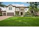 Charming two-story home with a stone entrance, lush landscaping, and a well-manicured lawn at 19711 Wellington Manor Blvd, Lutz, FL 33549