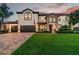 Well-manicured lawn and paver driveway lead to this two-story home with a three-car garage at 19711 Wellington Manor Blvd, Lutz, FL 33549