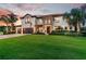 Attractive home with a manicured lawn, three-car garage, stone accents, and mature palm trees at 19711 Wellington Manor Blvd, Lutz, FL 33549