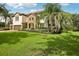 This home features a brick driveway, a manicured lawn, and lush landscaping at 19711 Wellington Manor Blvd, Lutz, FL 33549