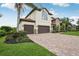 This home features a brick driveway, a manicured lawn, and a three-car garage at 19711 Wellington Manor Blvd, Lutz, FL 33549