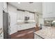View of the kitchen with stainless steel appliances, granite countertops, and white cabinets at 19711 Wellington Manor Blvd, Lutz, FL 33549