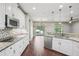Kitchen with mosaic backsplash, stainless appliances, granite countertops, and sleek white cabinets at 19711 Wellington Manor Blvd, Lutz, FL 33549