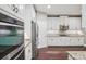 Contemporary kitchen with stainless steel appliances, granite countertops, and white cabinetry at 19711 Wellington Manor Blvd, Lutz, FL 33549