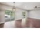 Open-concept living room with sliding doors to the pool area and views of waterfall feature at 19711 Wellington Manor Blvd, Lutz, FL 33549