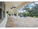 Covered patio featuring brick pavers and a view of a screened pool with a rock waterfall at 19711 Wellington Manor Blvd, Lutz, FL 33549